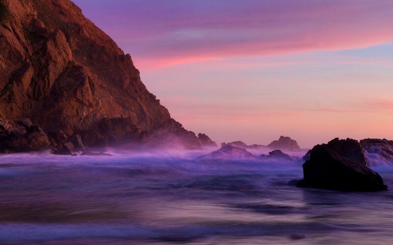 Purple sunset over rocky coast