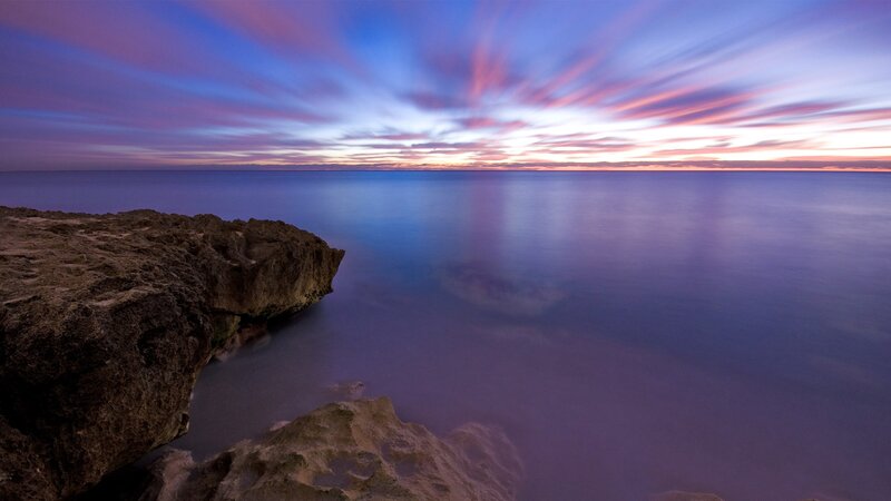 Purple sunset over rocky coast