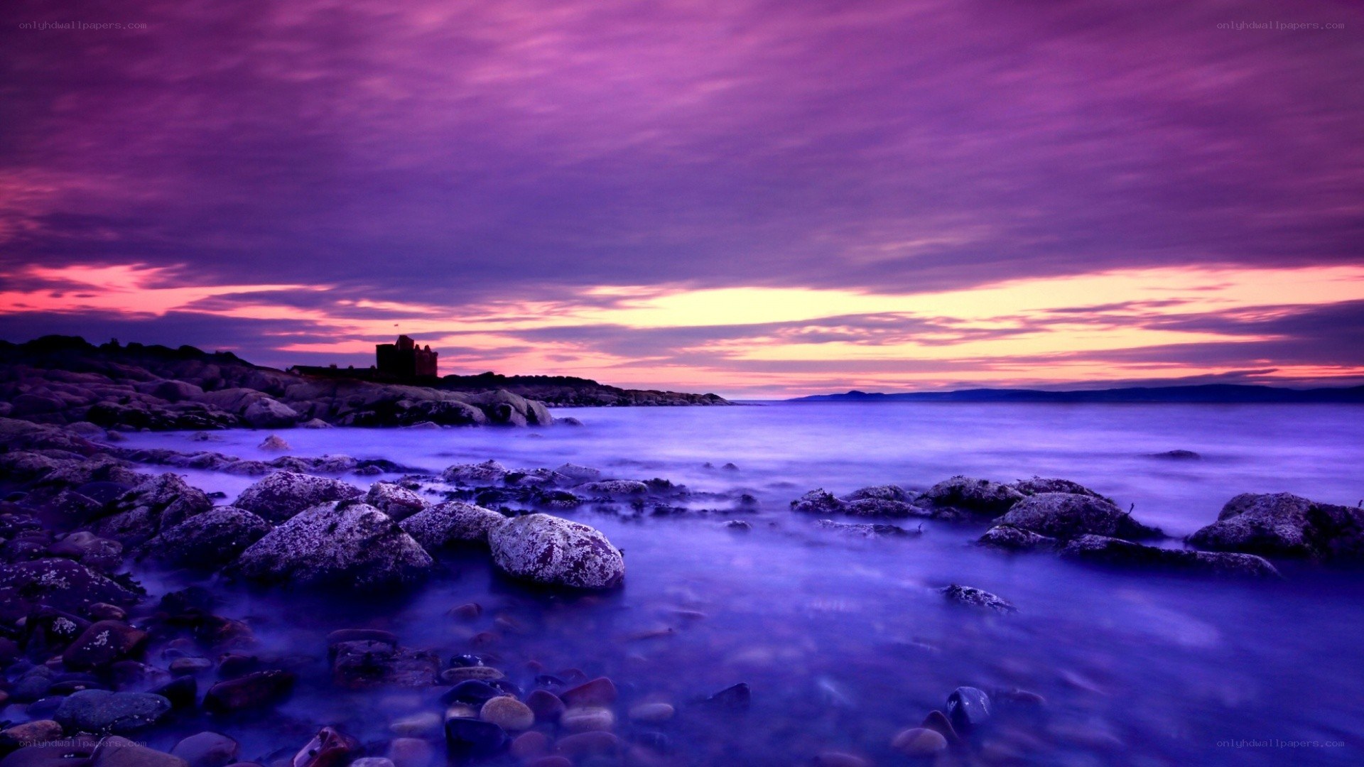 Purple sunset over rocky coast