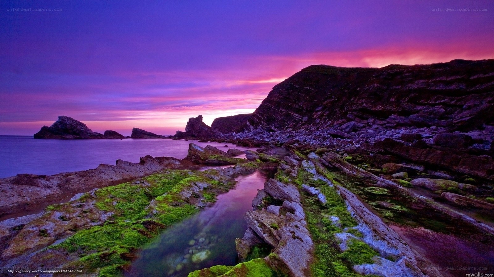 Purple sunset over rocky coast
