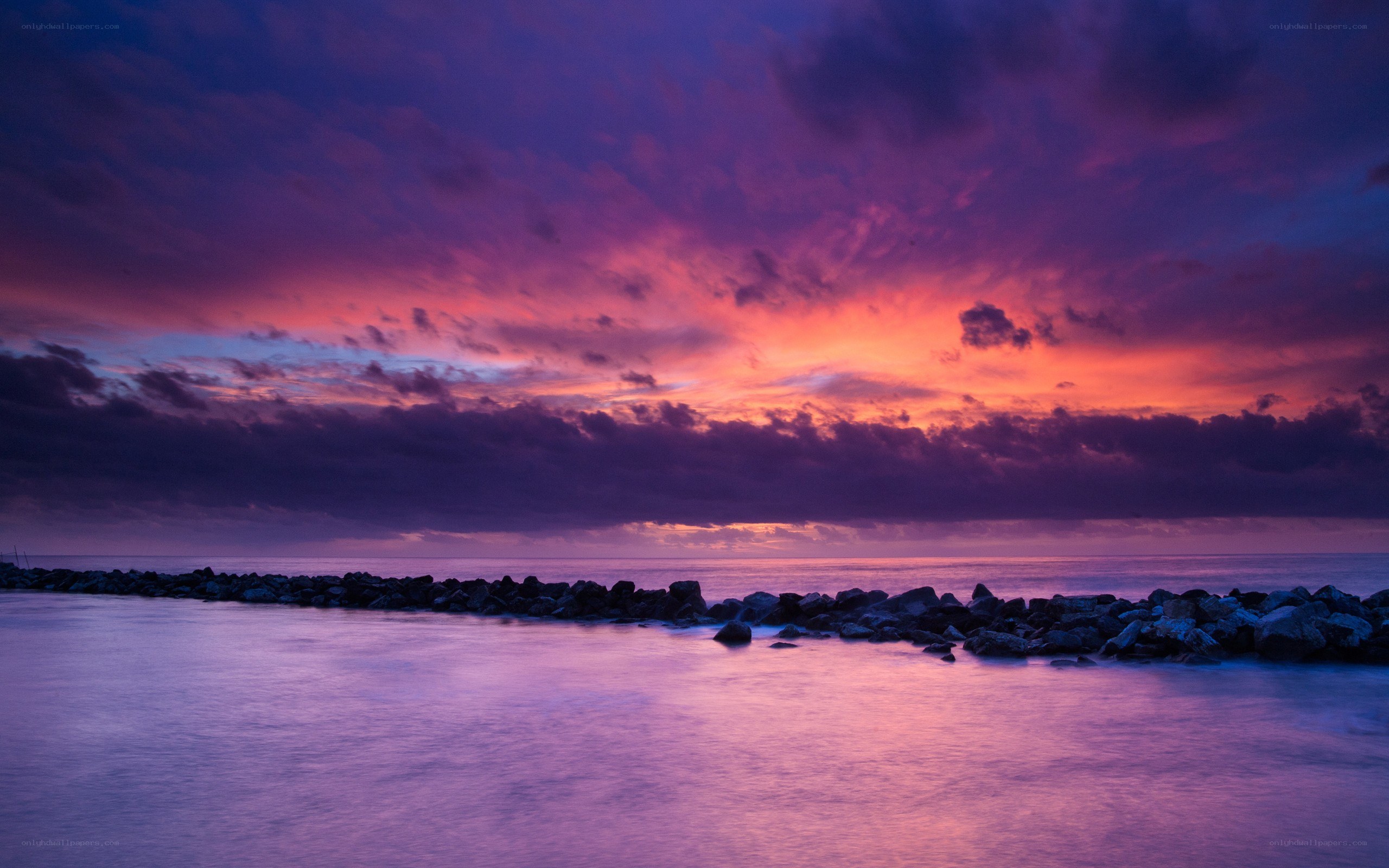 purple sunset over rocky pier