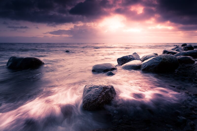 Purple sunset over rocky shore