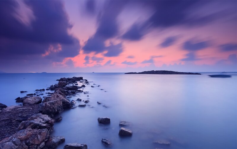 Purple sunset over rocky shore