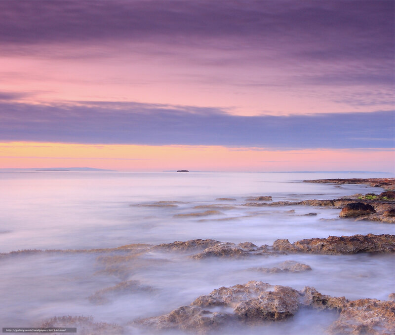 Purple sunset over rocky shore