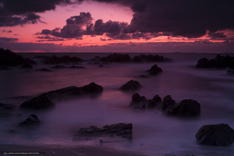 Purple sunset over rocky shore