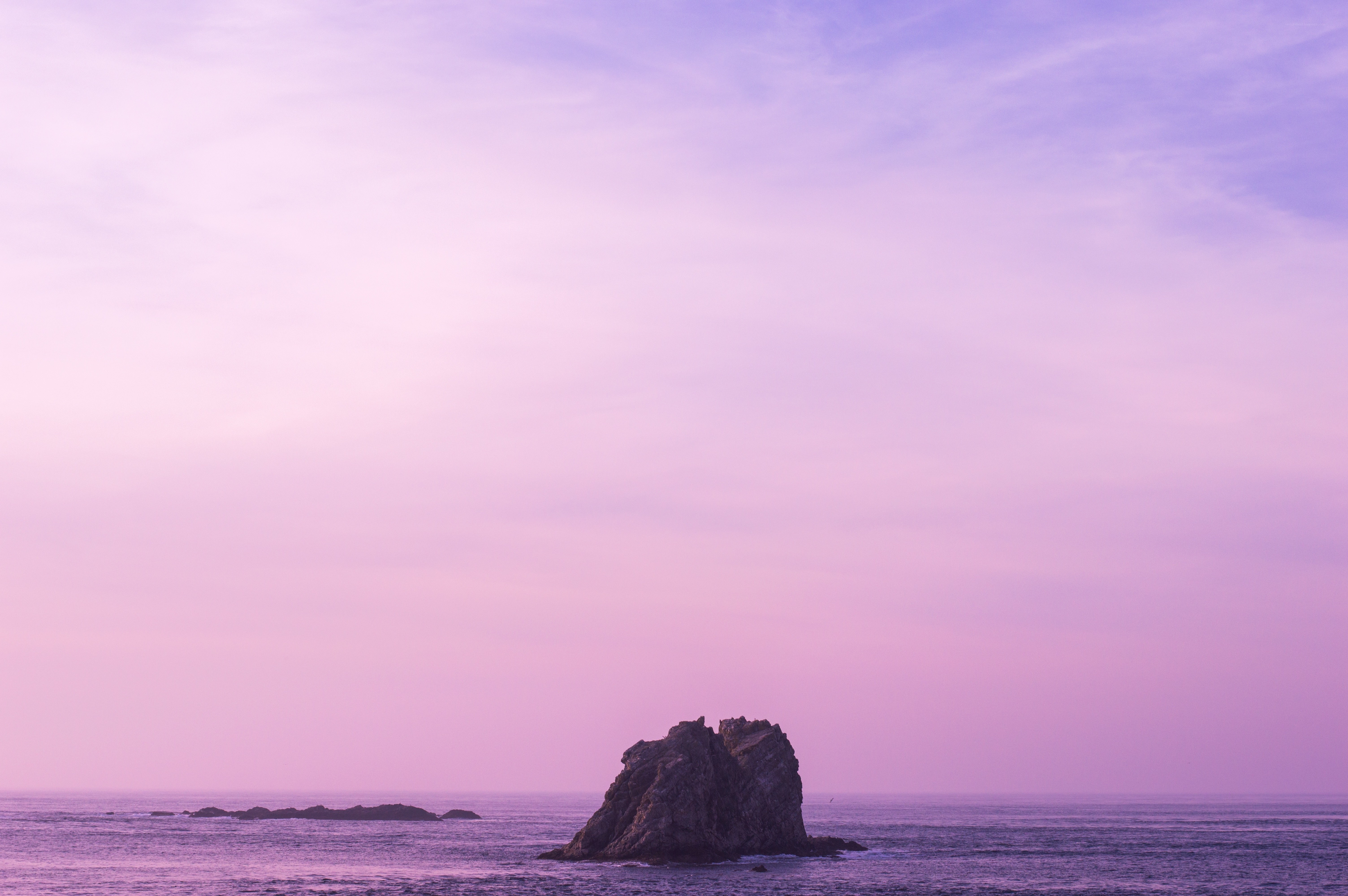 Purple sunset over sea rock