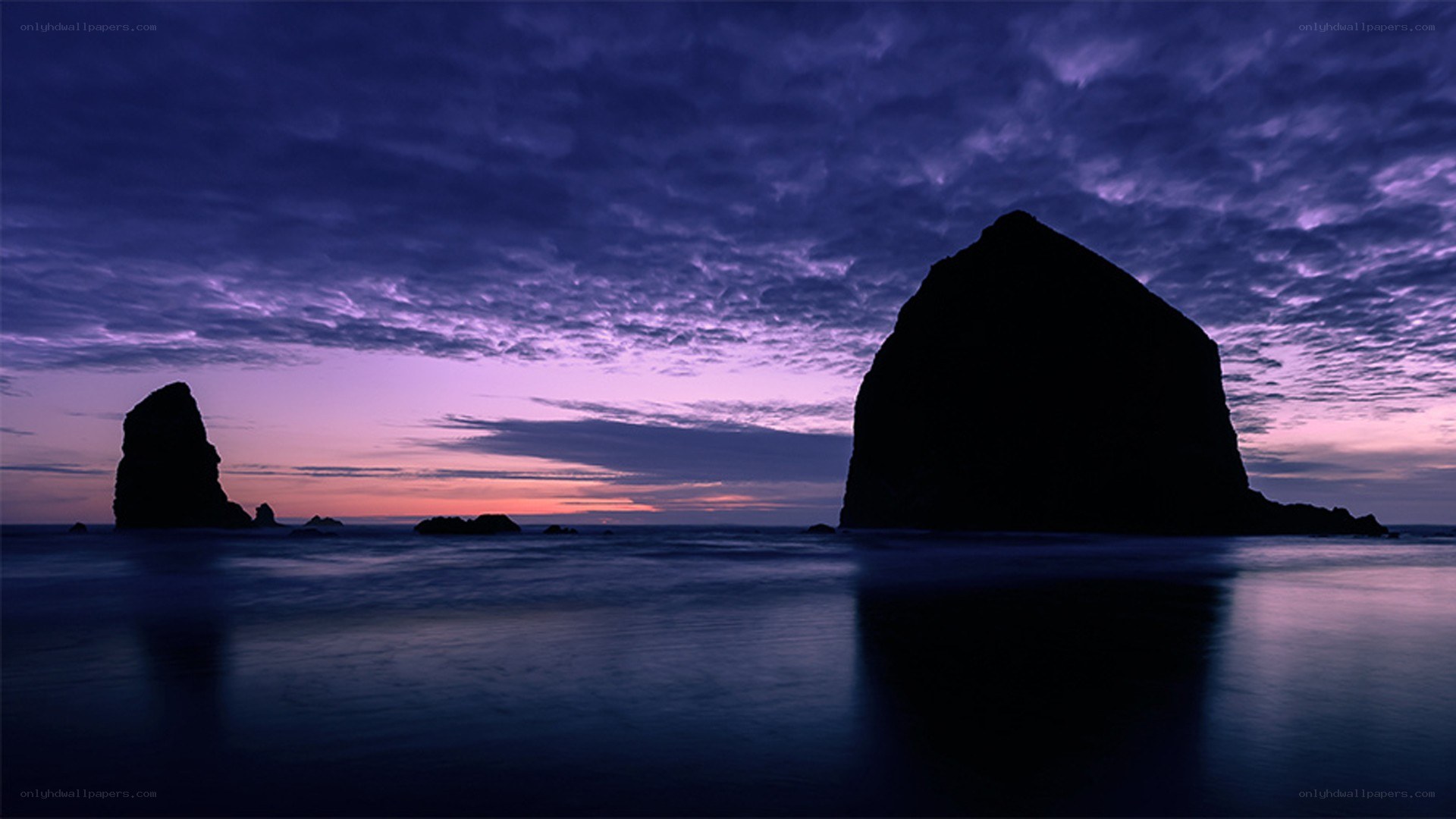 Purple sunset over sea rocks
