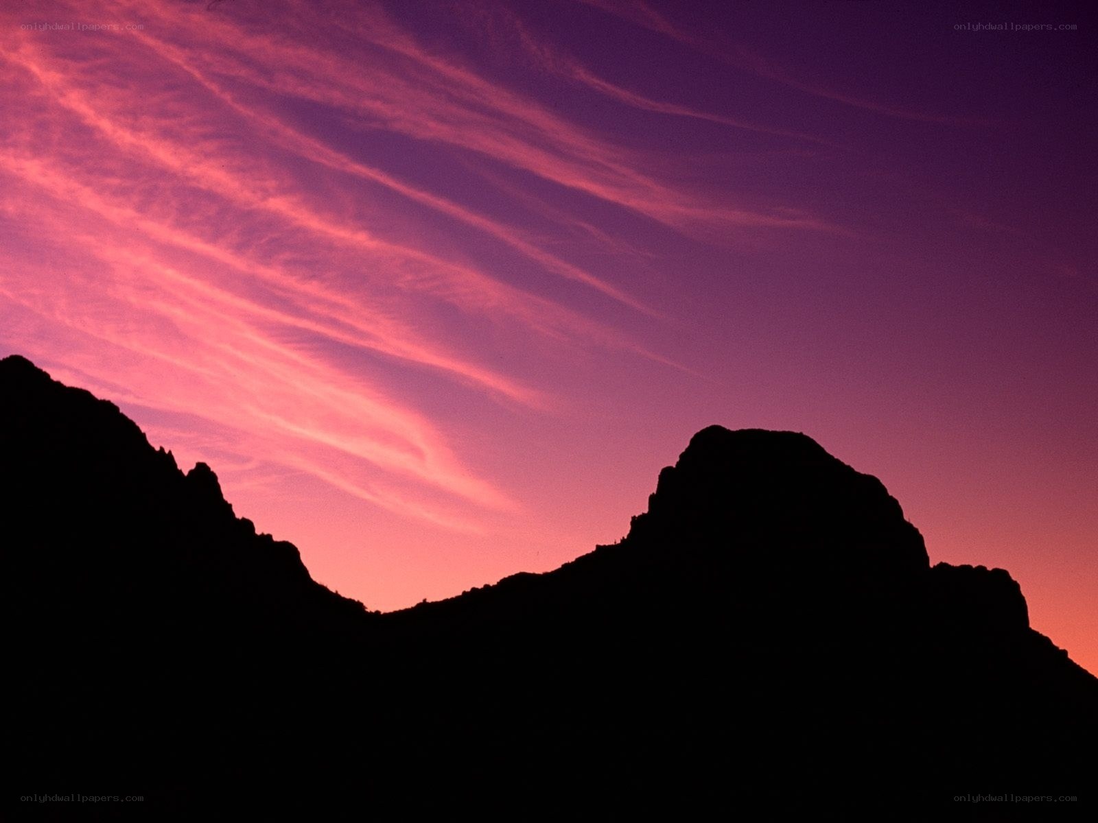 Purple sunset over silhouetted mountains
