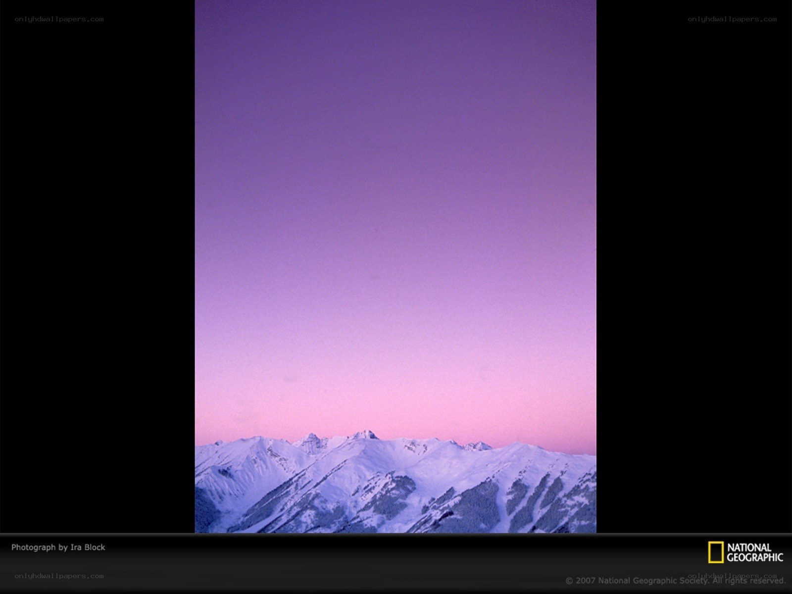 Purple sunset over snow-capped mountains