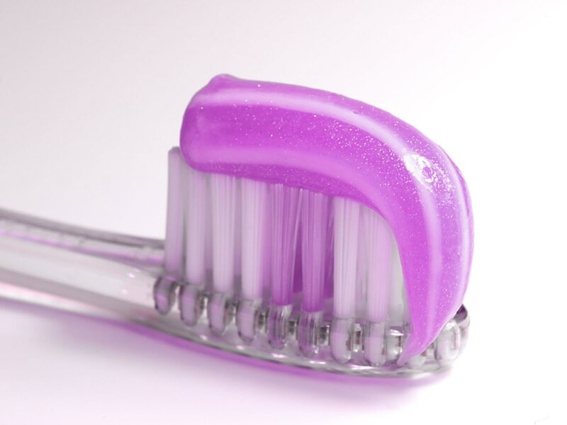 purple toothpaste on toothbrush