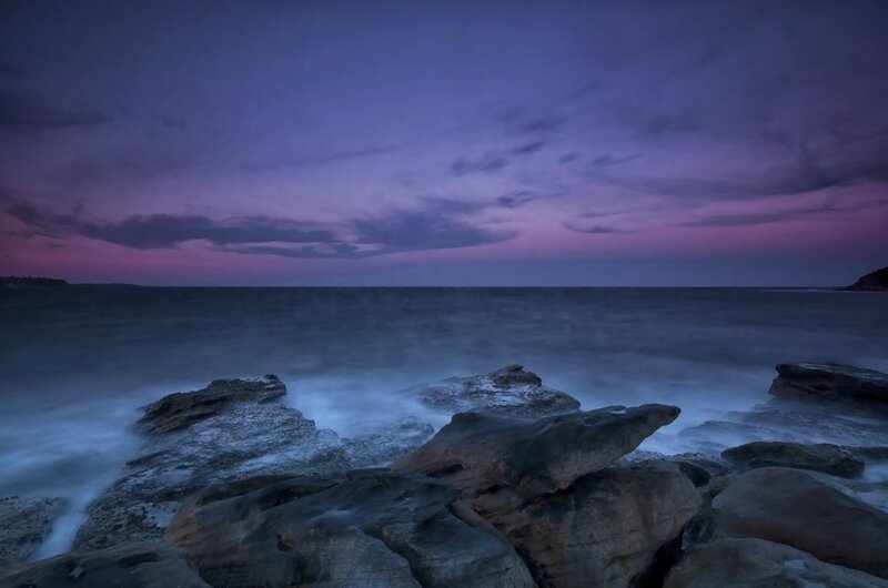 Purple twilight at the rocky shore