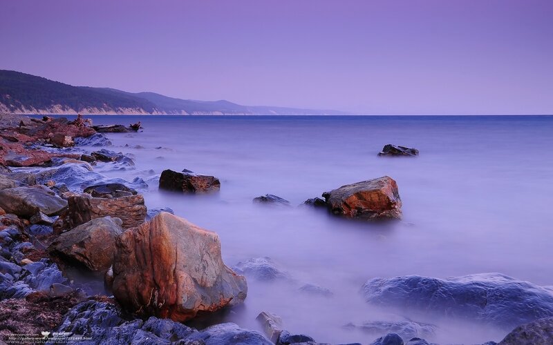 Purple twilight at the rocky shore