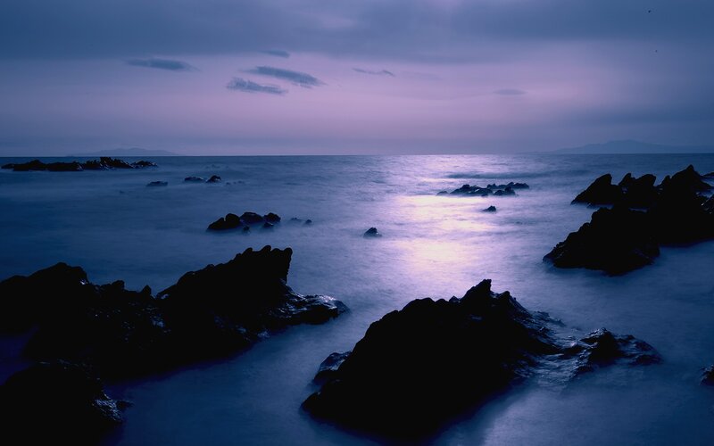 Purple twilight over rocky shore