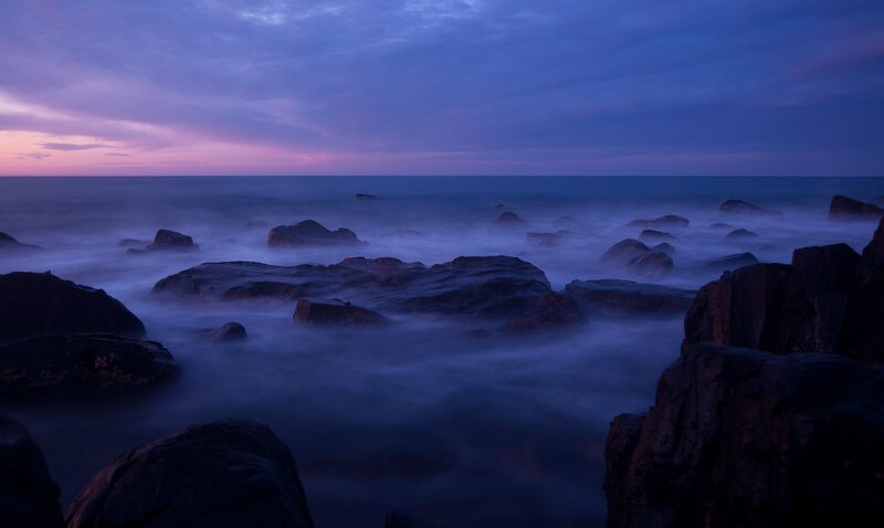 Purple twilight over rocky shore