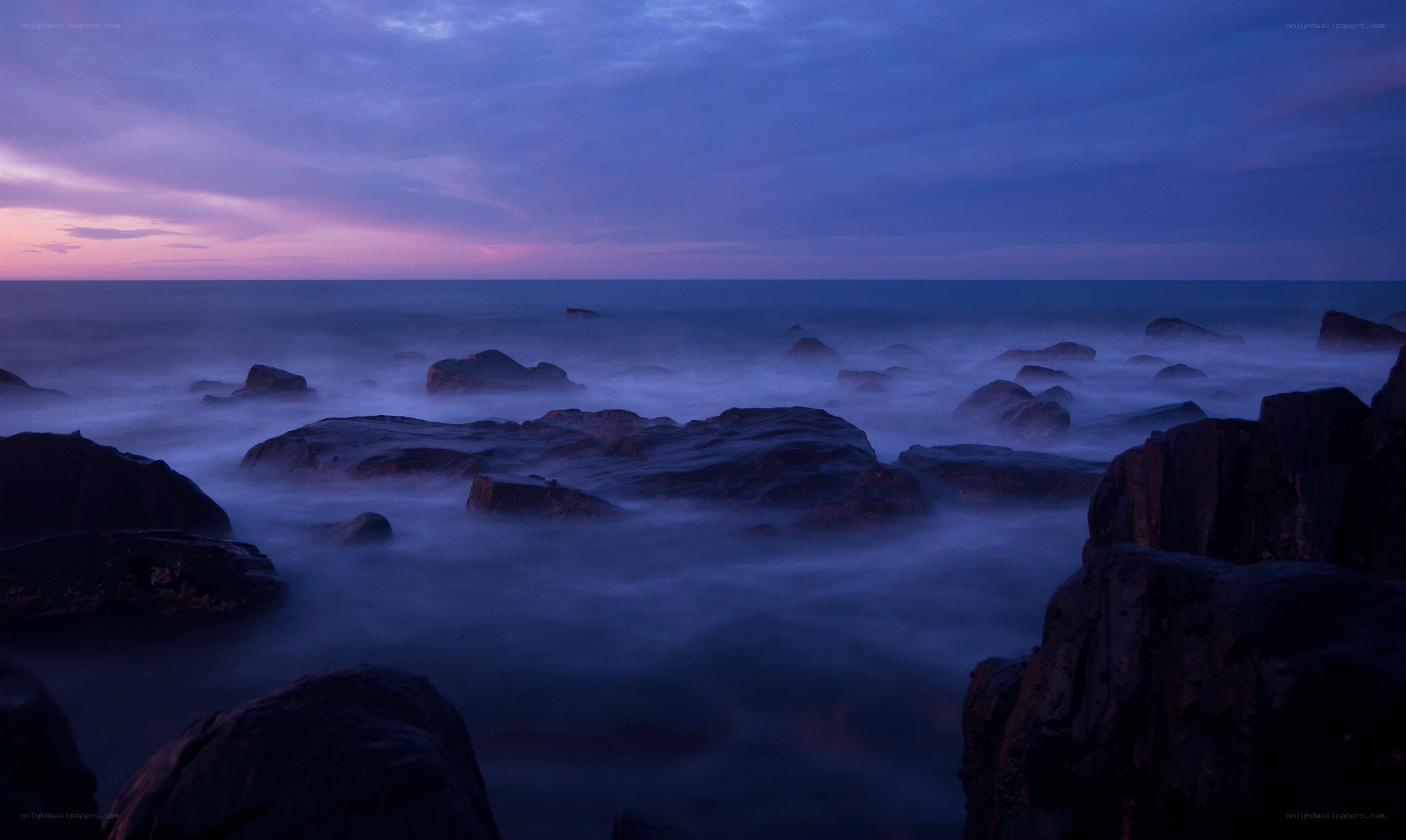 Purple twilight over rocky shore