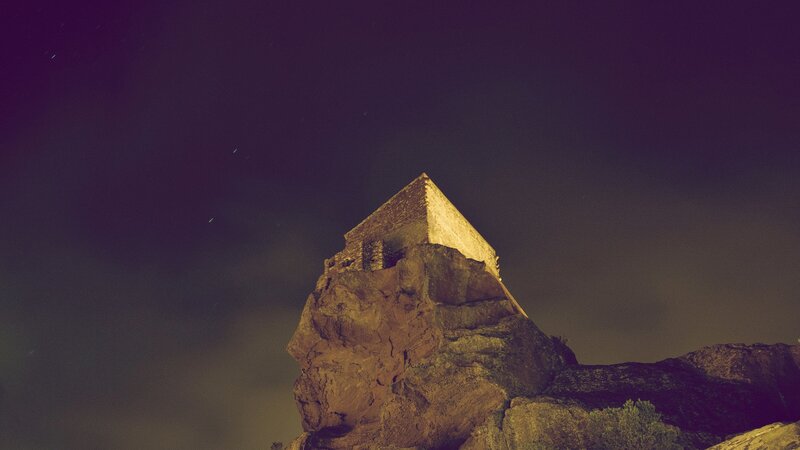Pyramid on a rocky outcrop at night