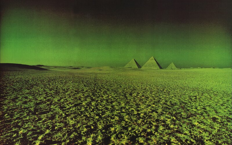 Pyramids under green sky