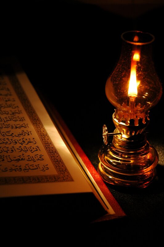 Quran illuminated by oil lamp