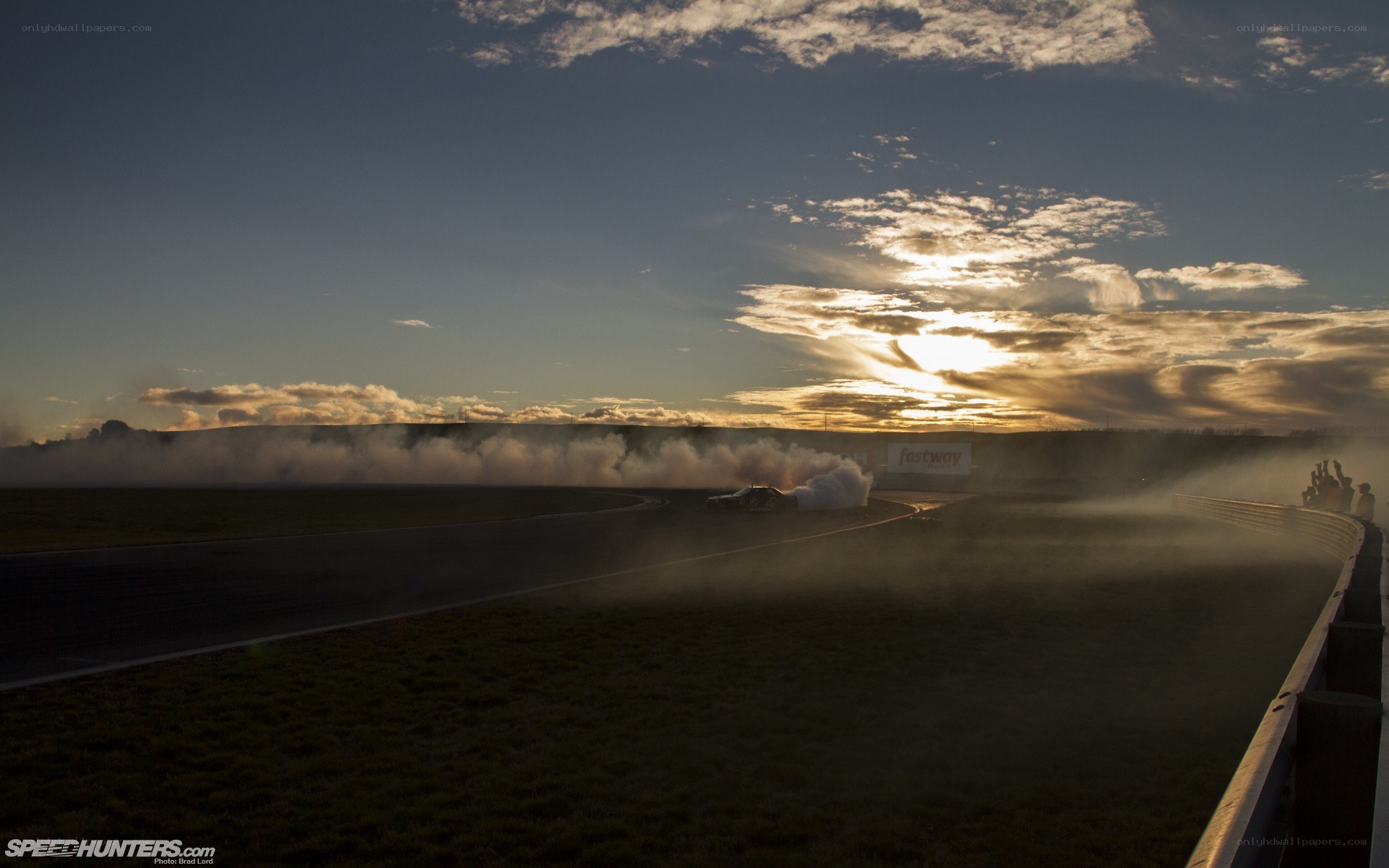 Race car drifting at sunset