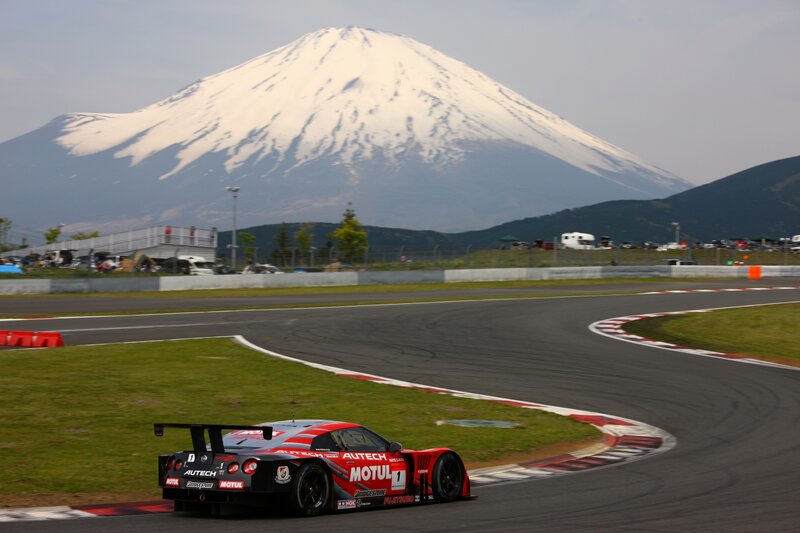 Race car on track with Mount Fuji