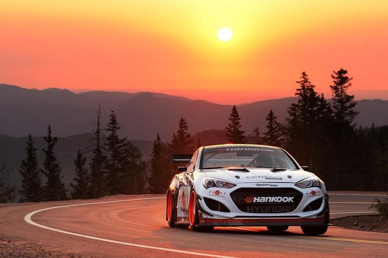 Race car on winding road at sunset