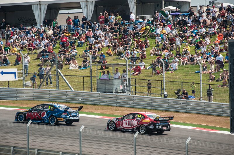 Race cars on track with crowd