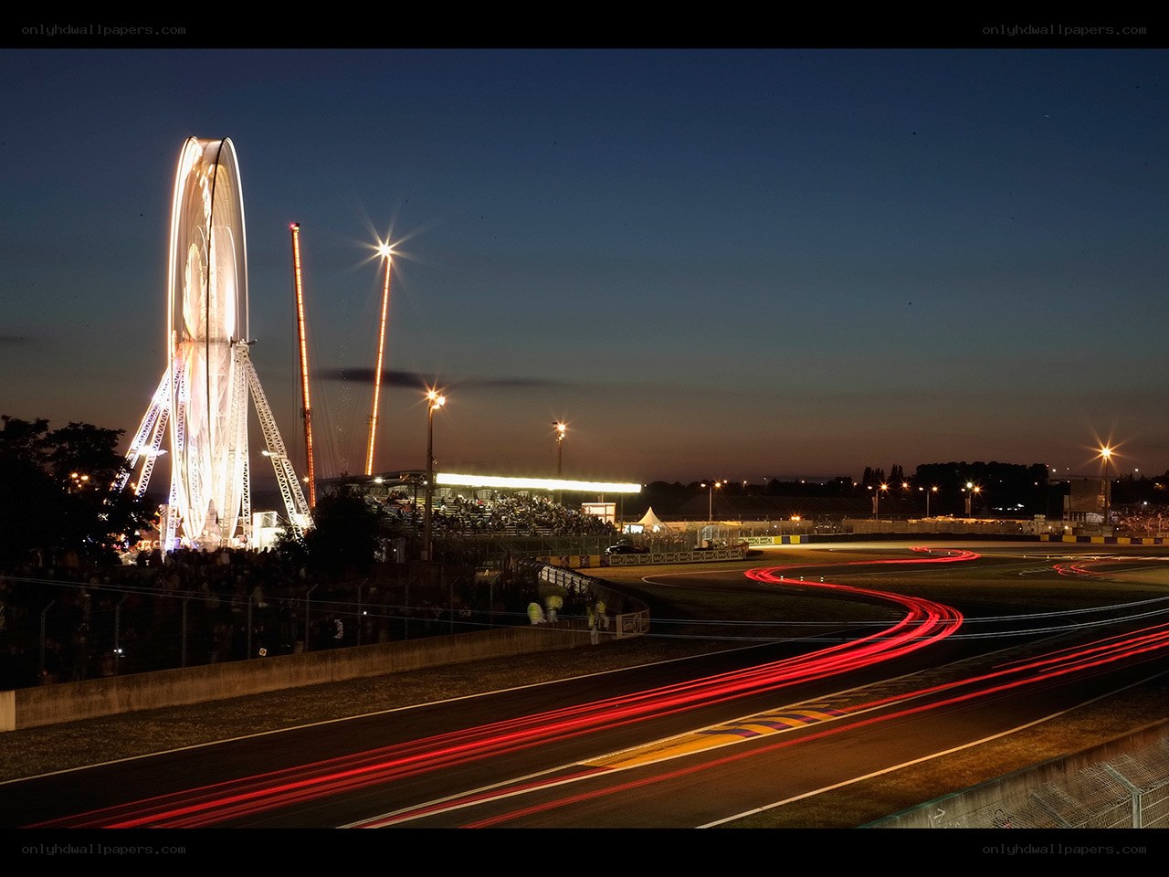 Race track at dusk with ferris wheel