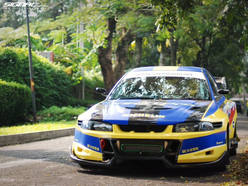 racing car on a tree-lined road