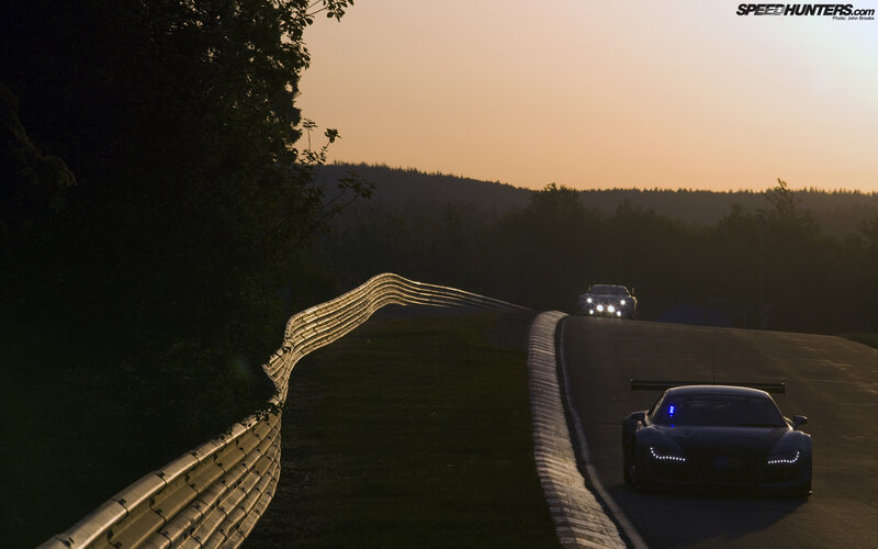 Racing cars on a track at dusk