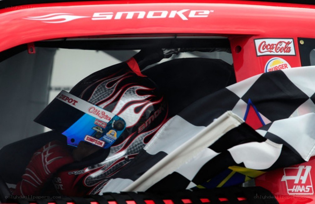 racing driver in cockpit with checkered flag