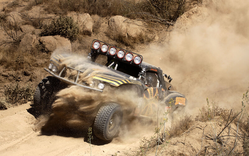 Racing off-road vehicle on dusty trail