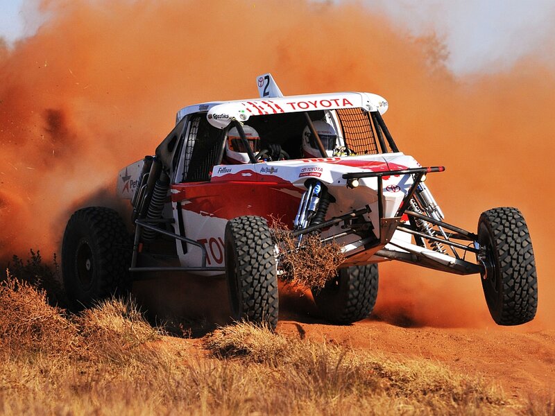 Racing Truck Kicking Up Dust — Orange