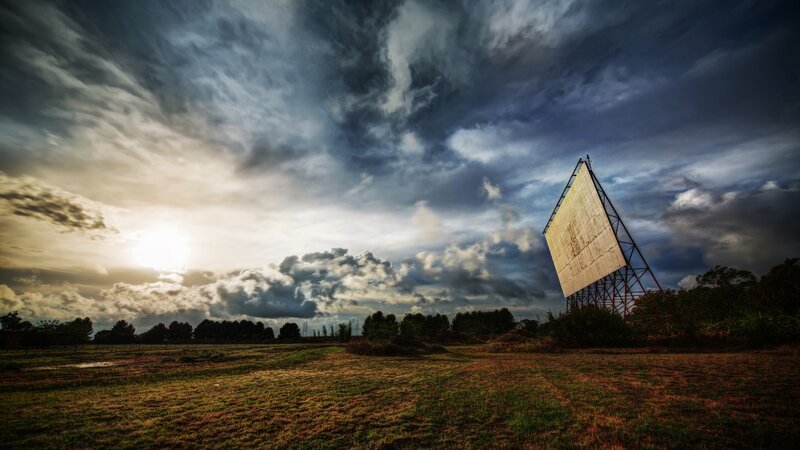 Radar dish in a field at sunset