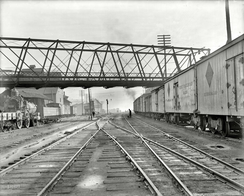 Rail yard with freight cars and bridge