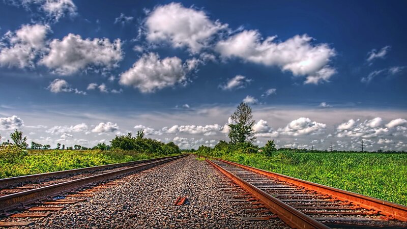 Railroad tracks under a cloudy sky