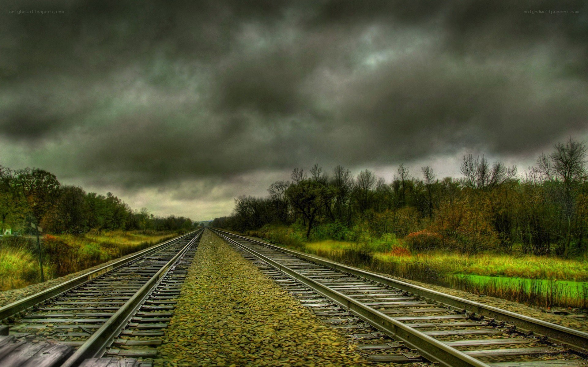 Railroad tracks under stormy sky