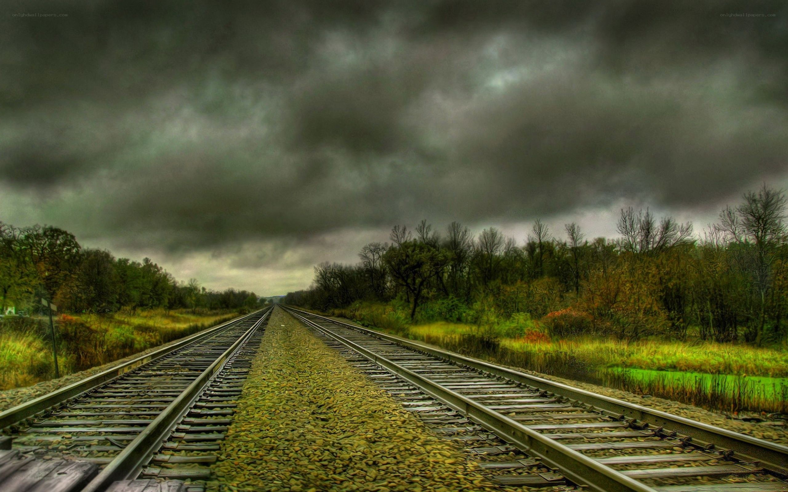railroad tracks under stormy sky