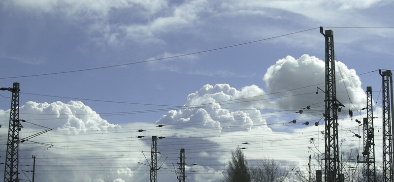 Railway power lines under cloudy sky