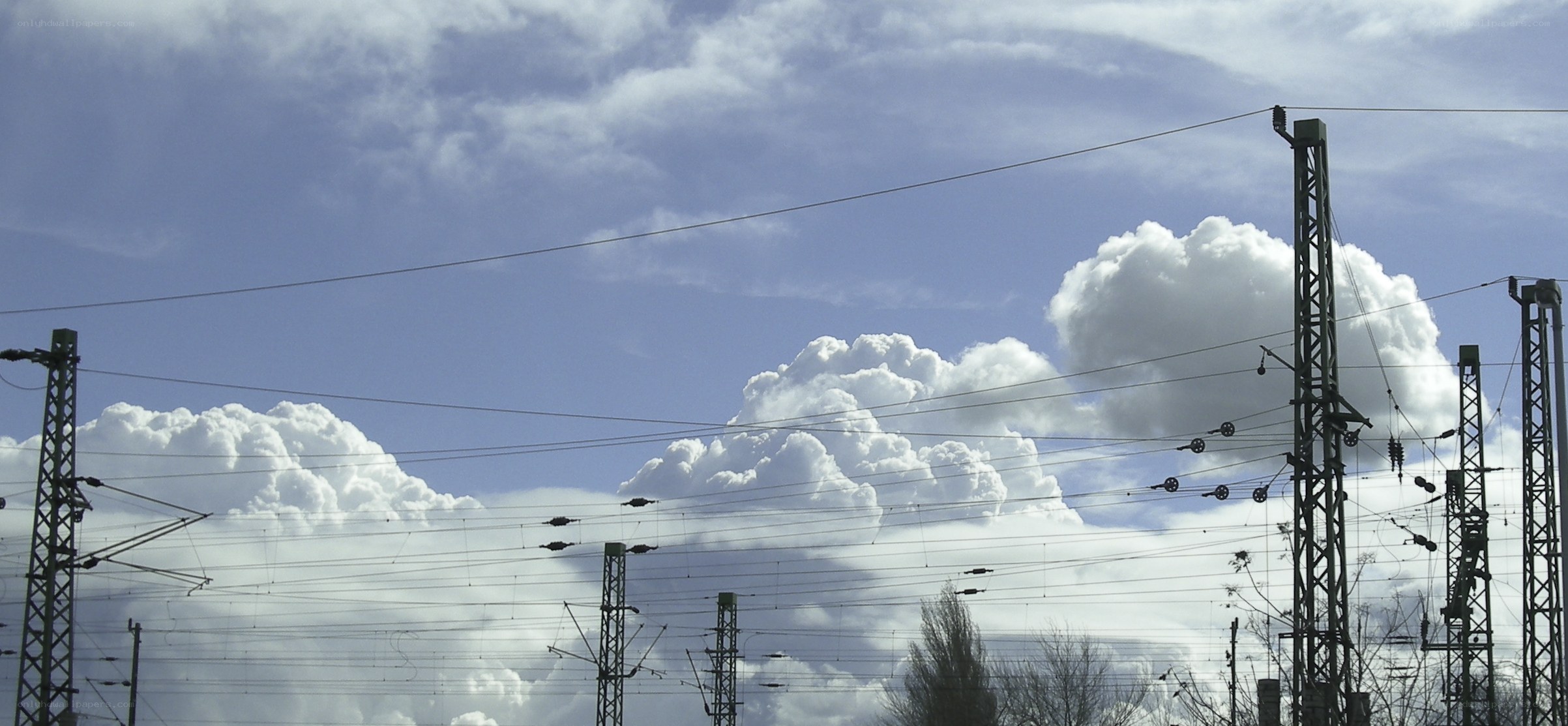Railway power lines under cloudy sky