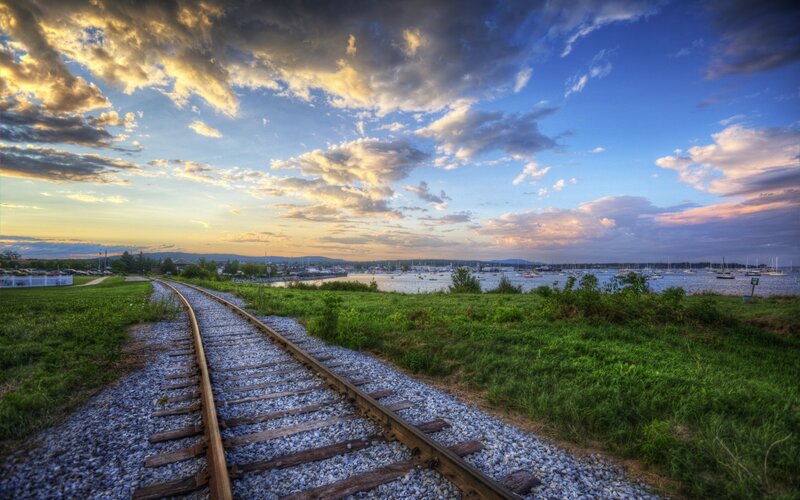 Railway tracks by the water at sunset