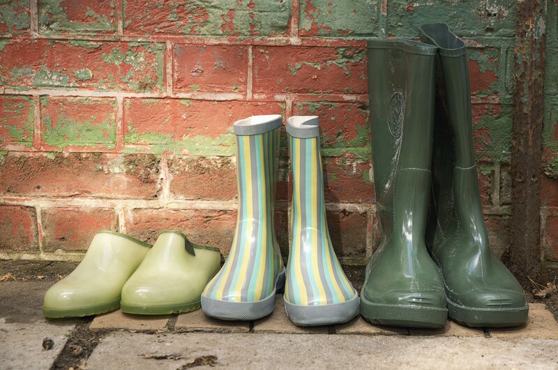 Rain boots against a brick wall