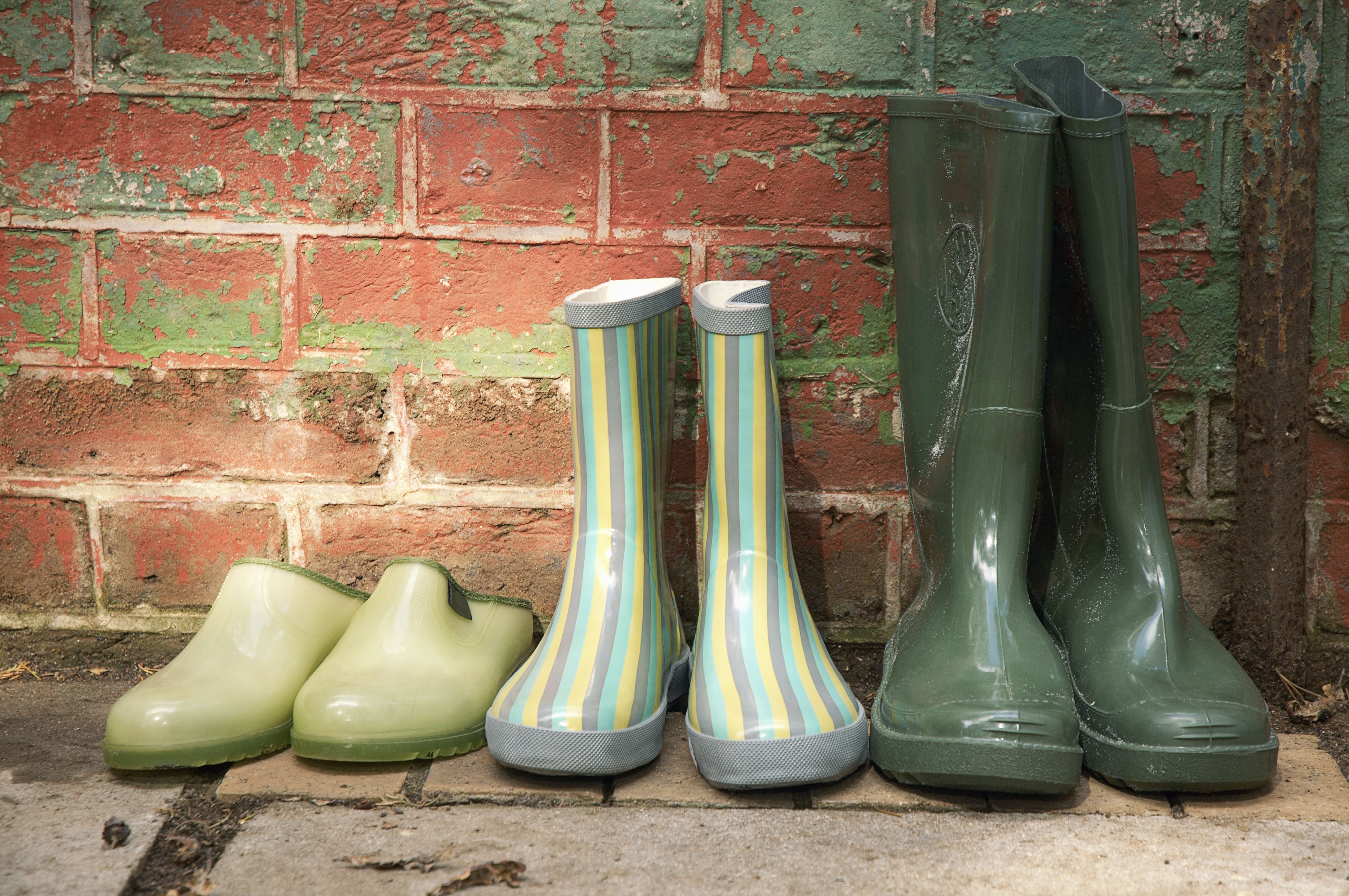 Rain boots against a brick wall