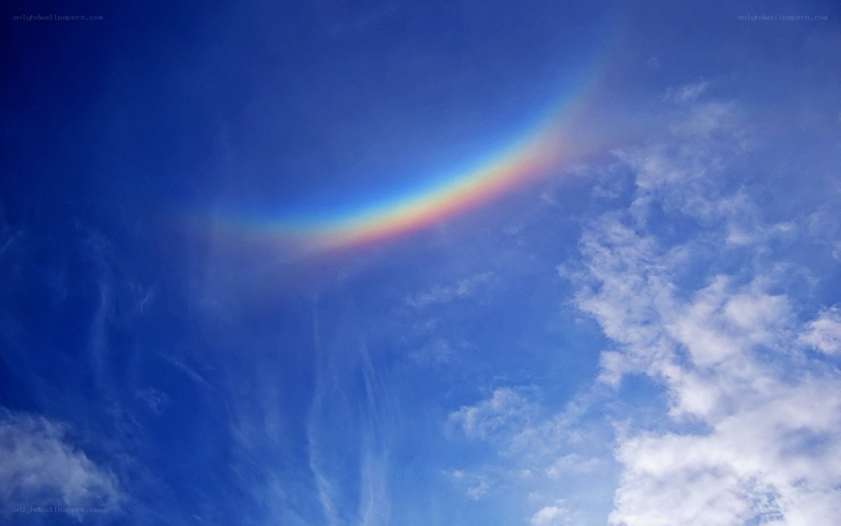Rainbow arc in blue sky
