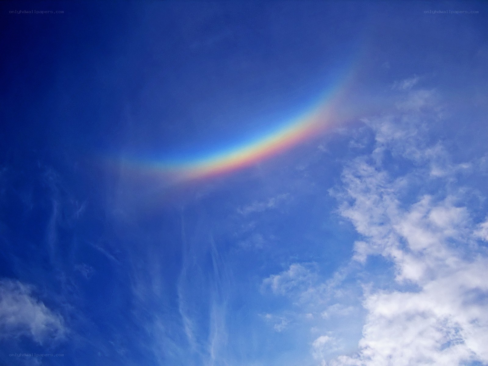 Rainbow arc in blue sky