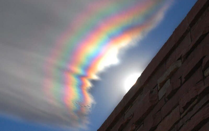 rainbow cloud over brick wall