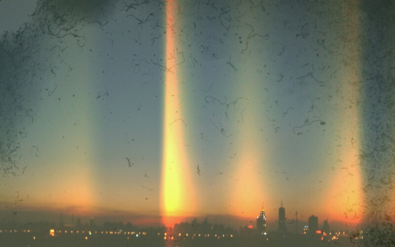 Rainbow light beams over city