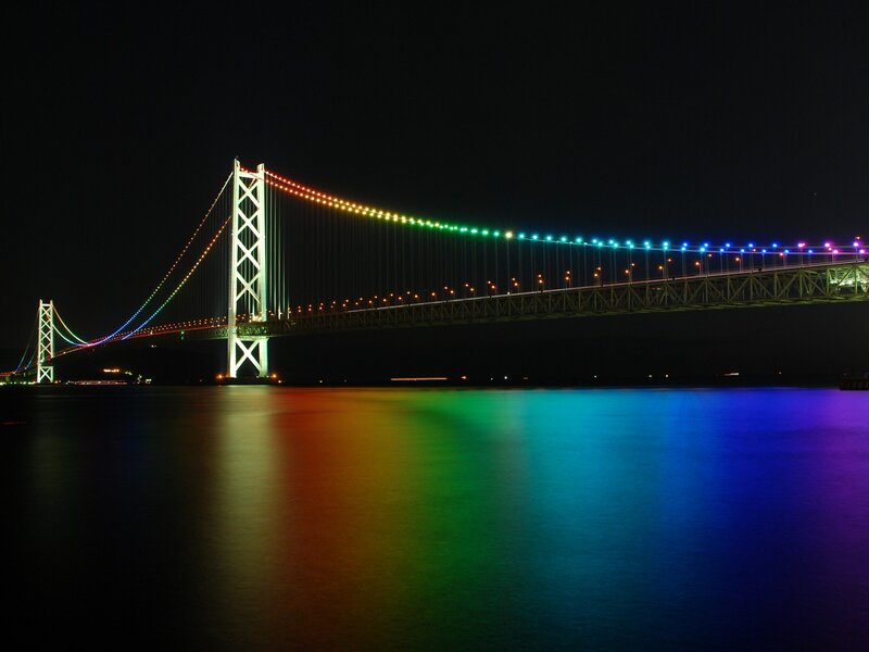 Rainbow-lit suspension bridge at night