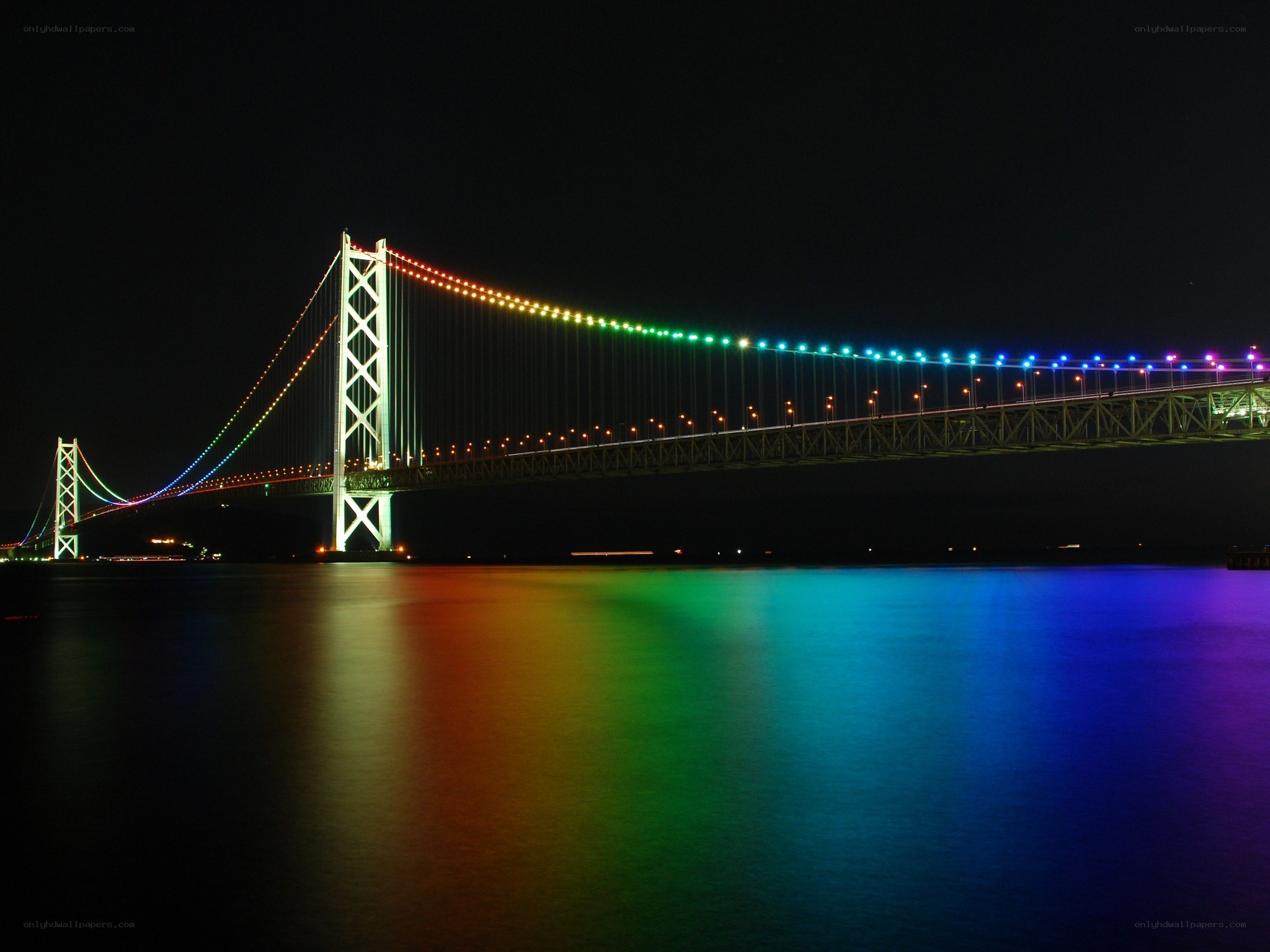 Rainbow-lit suspension bridge at night