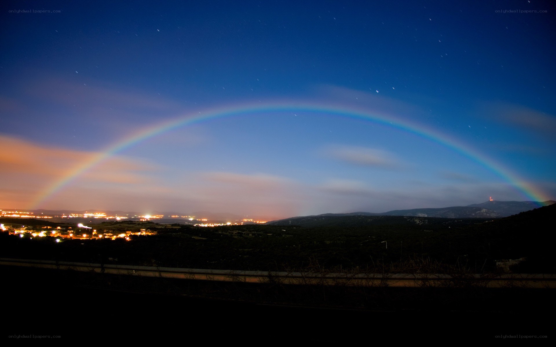 rainbow over a city at night