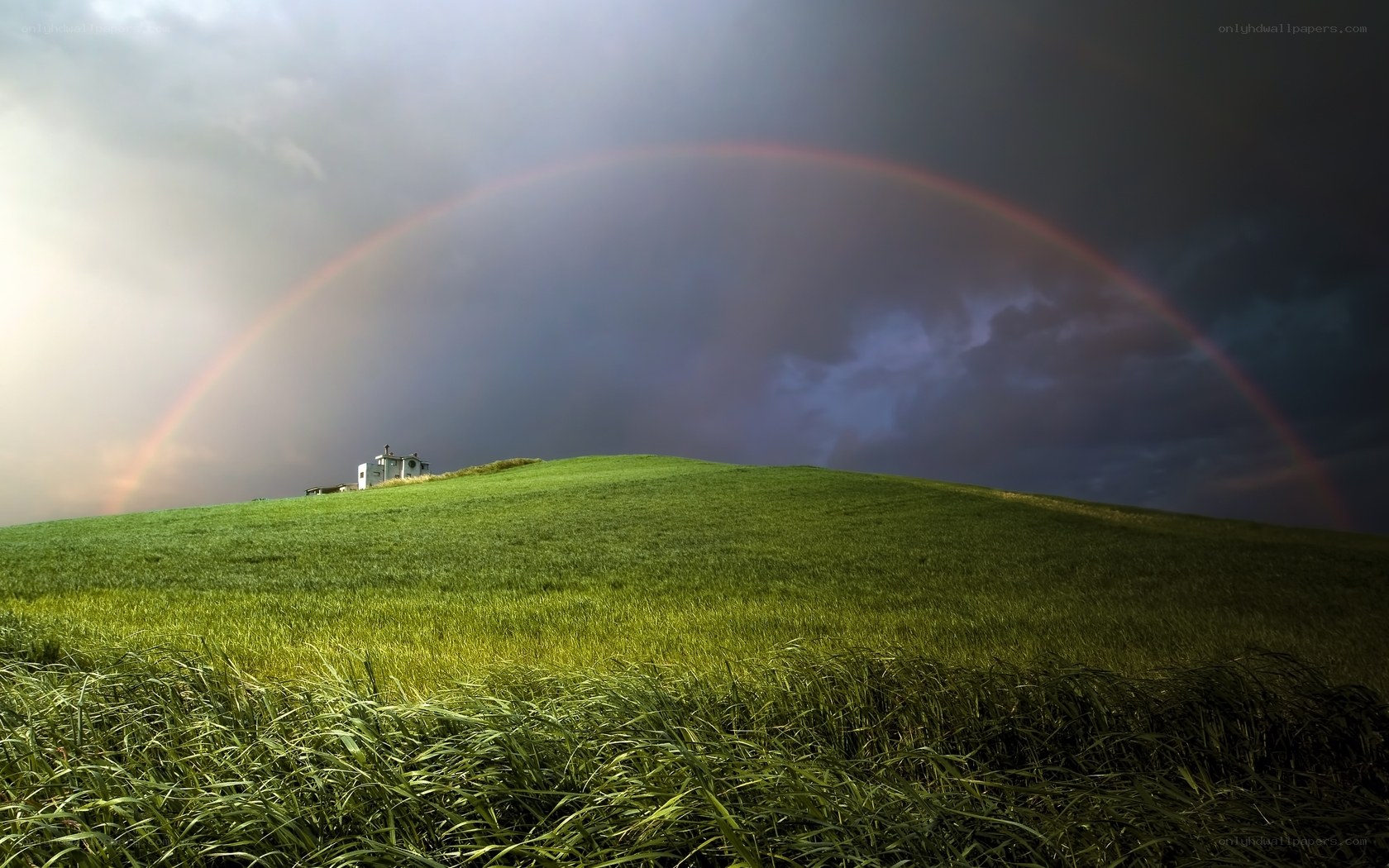 Rainbow over a green hill